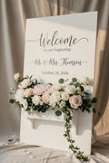 White wedding sign with flower box featuring white and blush florals and calligraphy